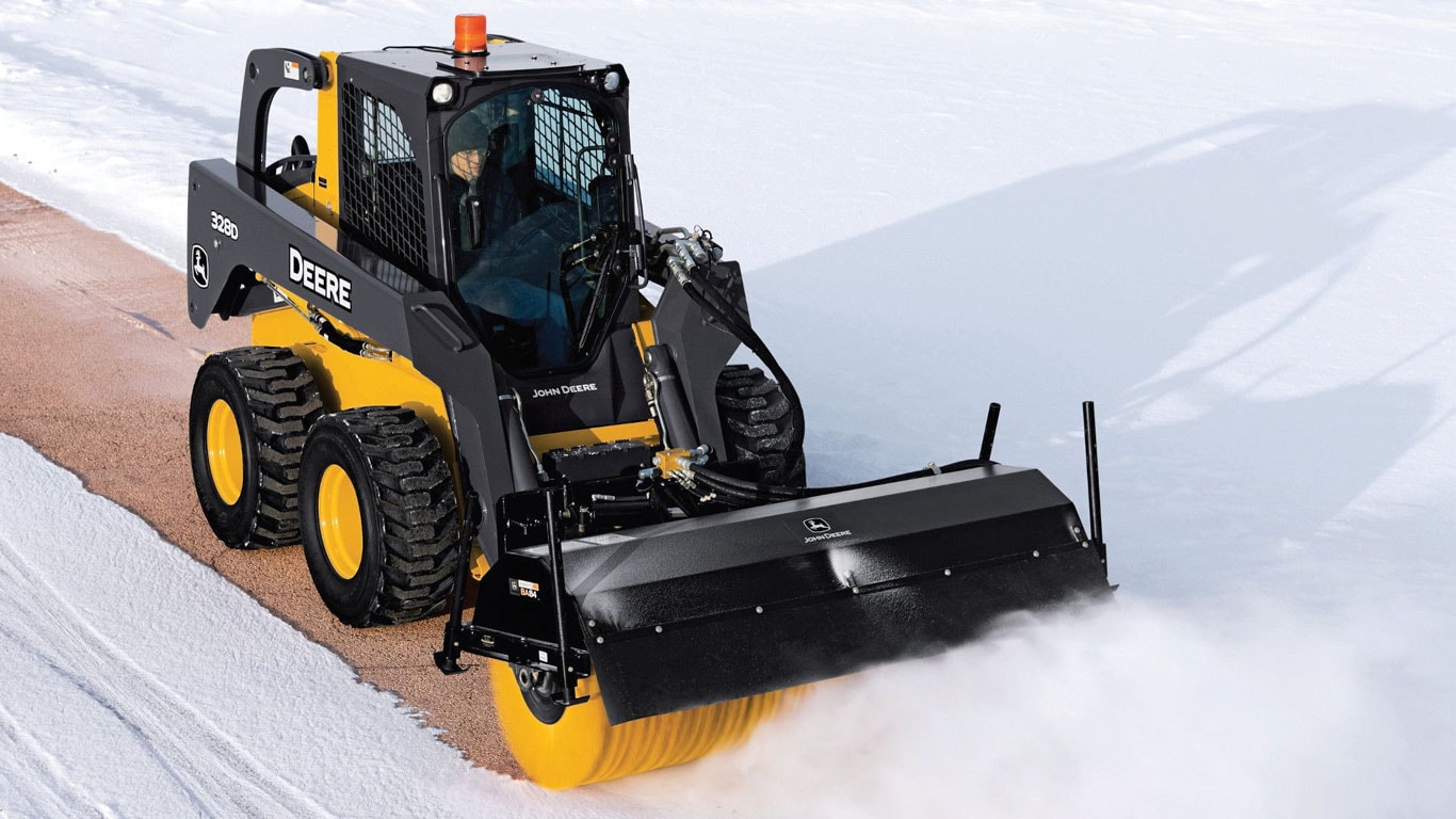 John Deere Skid Steer with Angle Broom attachment sweeping snow.